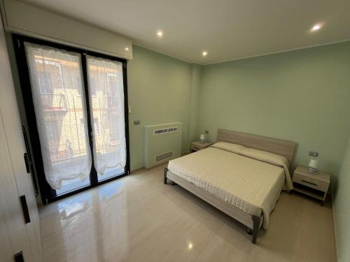 a bedroom with a bed and a large window at Mini Condominio Privato in Loano