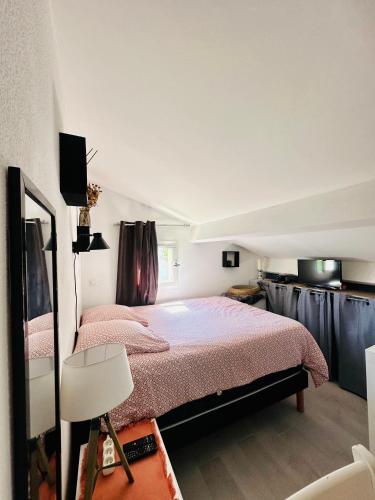 une chambre avec un lit avec literie rose et une cuisine dans l'établissement Maison avec jardin et piscine, à La Motte