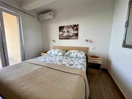 a small bedroom with a bed and a window at Apartments Nevenka i Josko in Tučepi