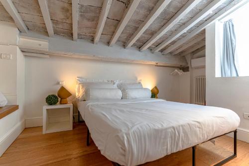 a bedroom with a large white bed and a window at Fossi tower in Florence