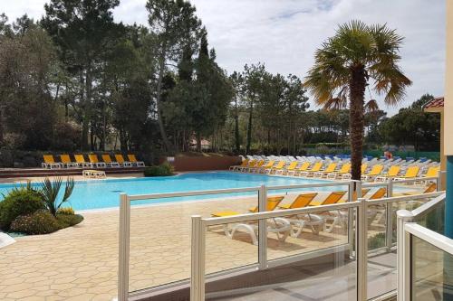 une piscine avec des chaises longues et un palmier dans l'établissement Mobil home 6 personnes, à Saint-Jean-de-Monts