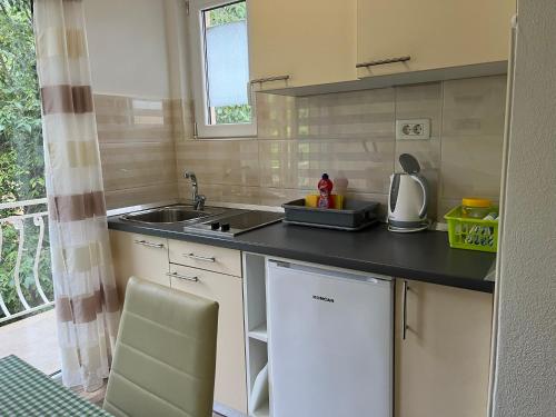 a small kitchen with a sink and a counter at Apartments Nevenka i Josko in Tučepi