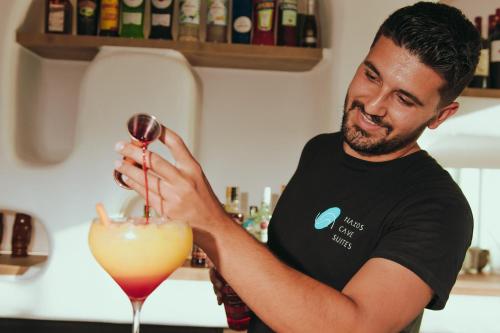 a man pouring a drink into a martini glass at Naxos Cave Suites in Stelida