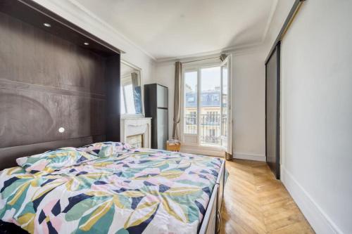 - une chambre avec un grand lit et une couette colorée dans l'établissement 3-bedroom apart close to Roland Garros, à Paris