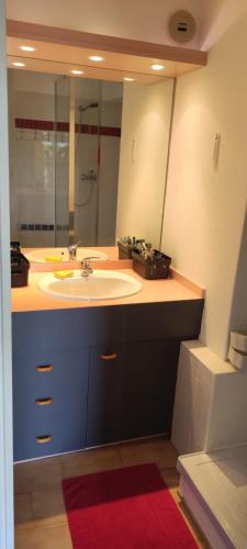 une salle de bain avec un lavabo et un grand miroir dans l'établissement Joli studio avec piscine à 200m de la plage parking privé, à La Grande Motte