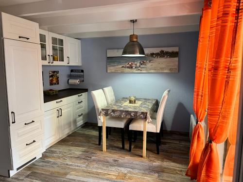 une salle à manger avec une table et deux chaises dans l'établissement Hameaux de la plage, à Gruissan