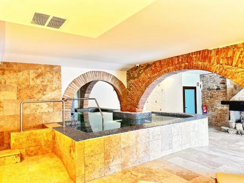 een kamer met een stenen muur met twee bogen bij AlliOli Boutique Hotel Spa in Castelló d'Empúries