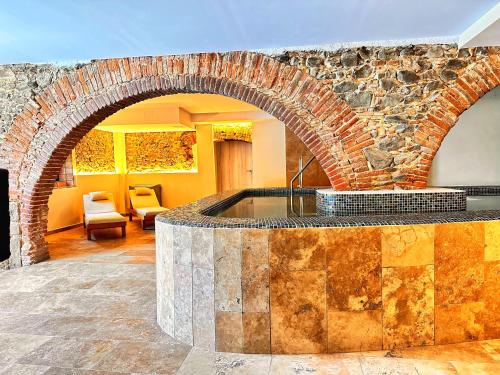a brick fireplace in a living room with a stone wall at AlliOli Boutique Hotel Spa in Castelló d'Empúries