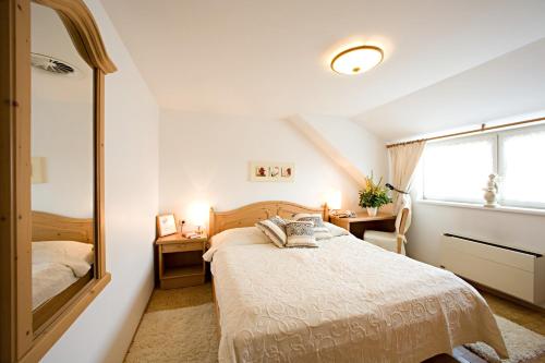 a bedroom with a bed and a mirror at Hotel & Restaurant Braunstein - Pauli´s Stuben in Purbach am Neusiedlersee