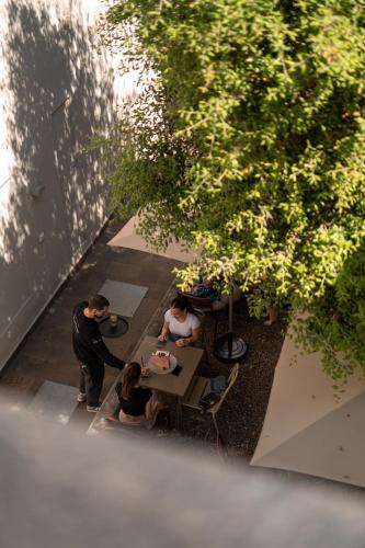 a group of people sitting at a table under a tree at Kuntino Suites in Merano