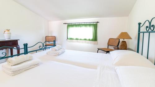 um quarto com uma cama branca com toalhas em Casa Via Leopardi 124 em Càbras