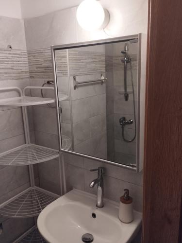 a bathroom with a sink and a shower with a mirror at Jenny's House II in Skiathos Town