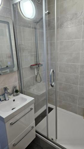 une salle de bain avec douche et lavabo dans l'établissement Appartement proche de la plage de Cabourg, à Cabourg