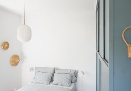 a white couch with pillows in a room with a window at A-ma-ru-to in Amarinthos