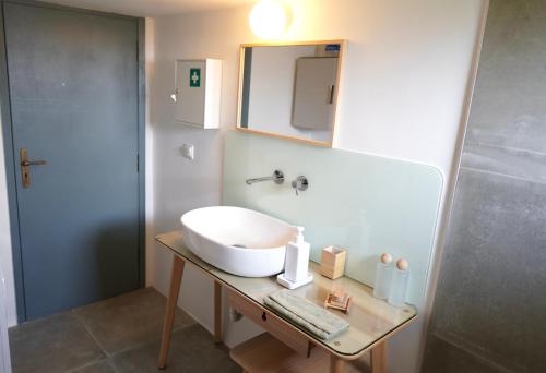 a bathroom with a sink and a mirror on a table at A-ma-ru-to in Amarinthos