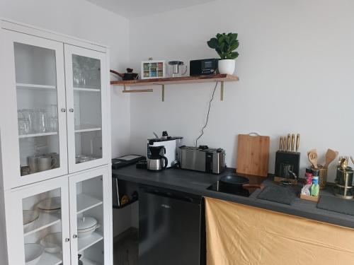 a kitchen with white cabinets and a counter top at FILMAP-Charmant-Modern-Zentral-Balkon-Beamer-Spieletisch in Görlitz