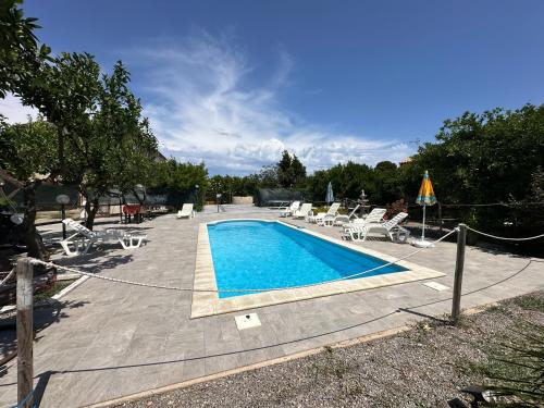 a swimming pool with a bunch of chairs at House Cefalù 1915 in Lascari
