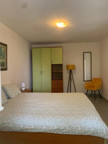 a bedroom with a bed and a green cabinet at House Orange Apartments in Herceg-Novi