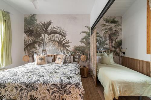 a bedroom with two beds with palm trees wallpaper at OASIS BEACH-CITY apartment in Montgat