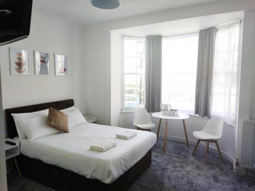 een slaapkamer met een bed en een tafel en stoelen bij Horizon in Brighton & Hove