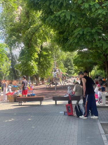 a group of people sitting on a bench in a park at Квартира in Almaty
