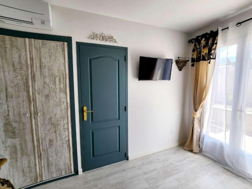 a blue door in a room with a window at Le Clos Renaissance in Oppède