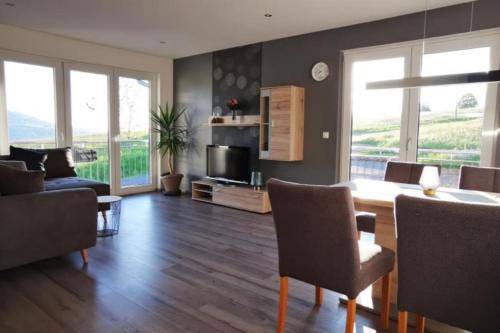 a living room with a table and chairs and a couch at Ferienwohnung BergPanorama Rhön in Gersfeld