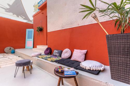 a couch sitting on the side of a building with pillows at Hostel Casa La Cha in Novalja