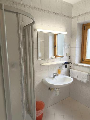 a white bathroom with a sink and a mirror at Schenna Garni Eden Bed & Breakfast in Schenna