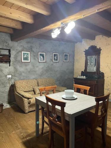 ein Wohnzimmer mit einem Tisch und einem Sofa in der Unterkunft Stone House: fairytale flat with magic lake view in Bellano