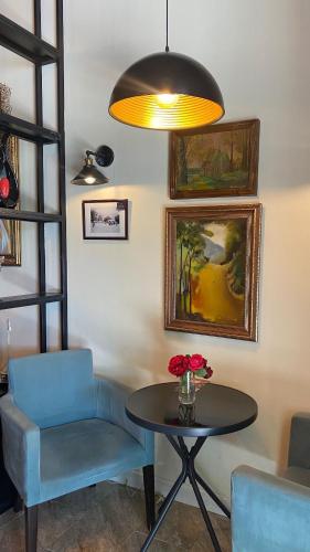 a room with a table and a chair and a lamp at Central Hostel in Sheki