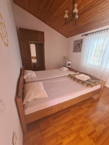 a large bed in a bedroom with a wooden ceiling at Apartment Zaglav 4 - first sea row in Zaglav