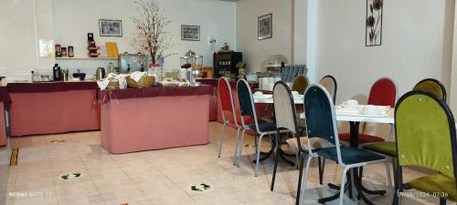 a restaurant with tables and chairs and a counter at Hotel Alnacir in Faro