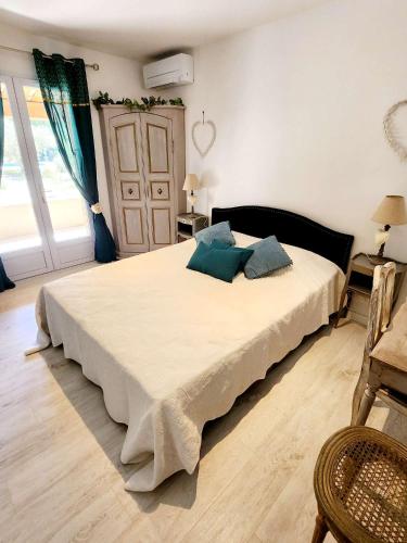 a bedroom with a large bed with blue pillows at Le Clos Renaissance in Oppède