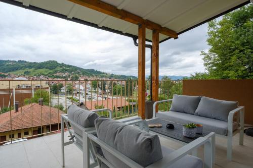 a patio with chairs and a table and a view of a city at Piramida Visoko in Visoko