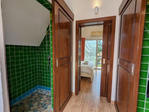 a bathroom with green tiled walls and a walk in shower at Beachfront Magic Villa - by KohChangVillas in Ko Chang