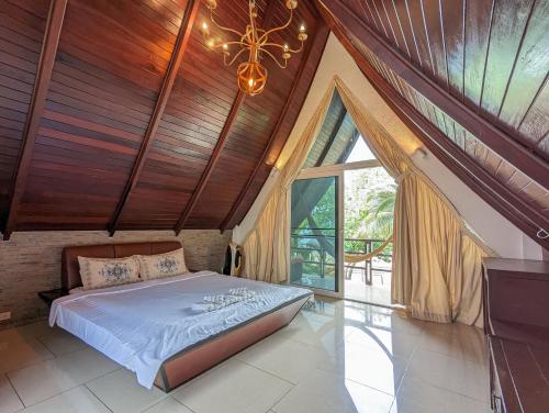 a bedroom with a bed and a large window at Beachfront Magic Villa - by KohChangVillas in Ko Chang
