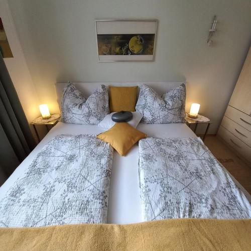 a bedroom with a white bed with two pillows at Ferienwohnung Energie Oase in Millstatt