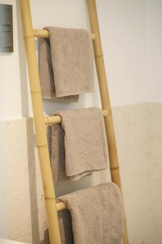a towel rack with four towels on it at Exklusives Strandapartment mit Parkplatz & direktem Zugang zum Meer in Srima
