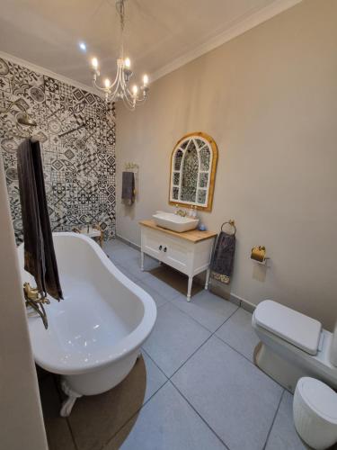 Un baño con bañera, lavabo e inodoro. en KarooSjiek Self-catering, en Adendorp