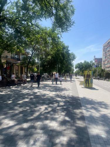 a street with people walking down a sidewalk at Юбилейный in Almaty