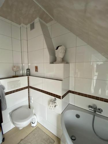 a bathroom with a toilet and a tub and a sink at Unter dem Dach mit Parkplatz in Bremen
