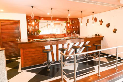 a kitchen with a bar with stools at it at Otium Goa Resort by The Oterra in Porvorim