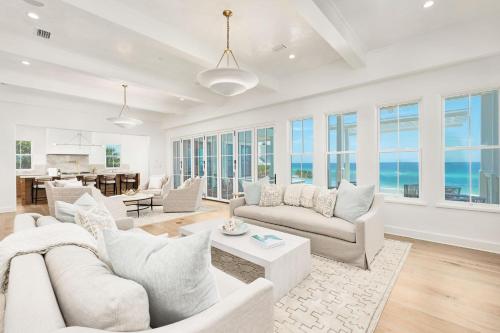 a living room with white furniture and large windows at Del Mar in Seacrest