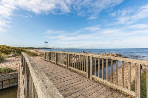 a wooden boardwalk to the beach on a sunny day at Giselas Ferienwohnung Ostsee in Holzstein in Oldenburg in Holstein