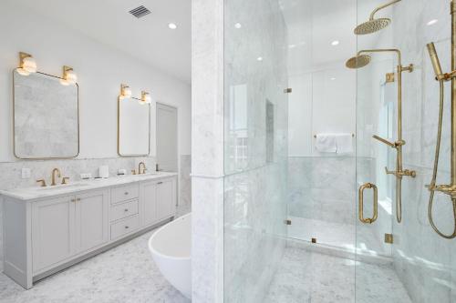 a white bathroom with a shower and a sink at Del Mar in Seacrest