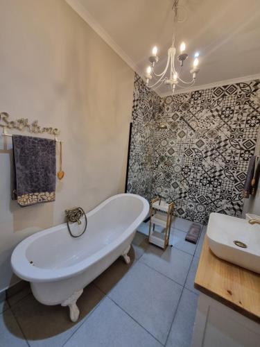 a bathroom with a large tub and a sink at KarooSjiek Self-catering in Adendorp