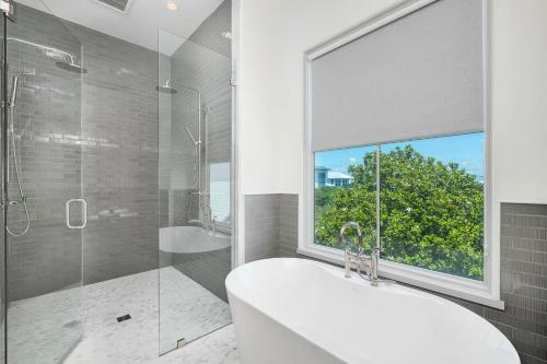 a bathroom with a tub and a shower with a window at Del Mar in Seacrest