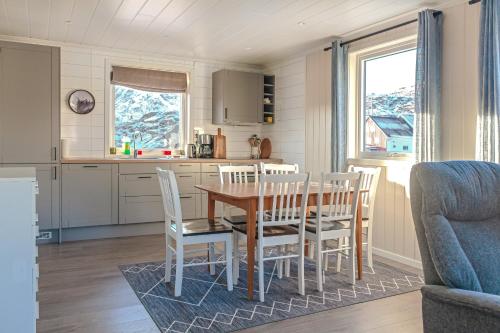 cocina y comedor con mesa y sillas en Damperiholmen cabin, en Sund