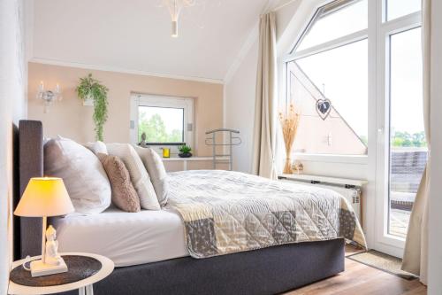 a bedroom with a bed and a large window at SmartFewo Loft Sauna Balkon Parkplatz in Bad Zwischenahn